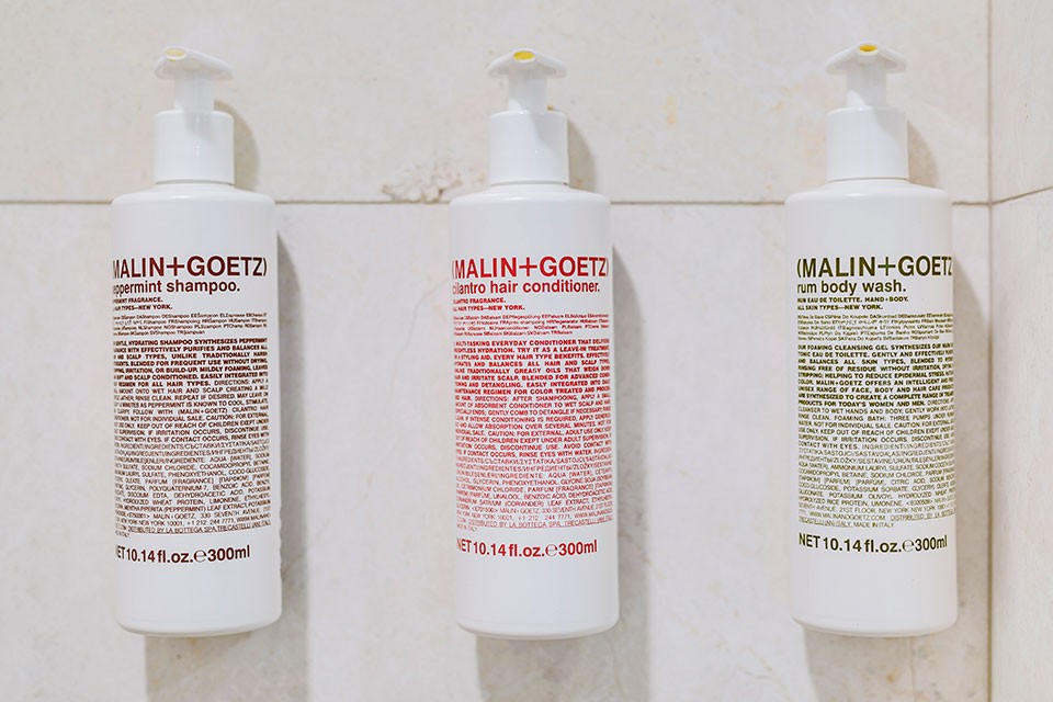 Malin+Goetz luxury bath amenities on shower wall