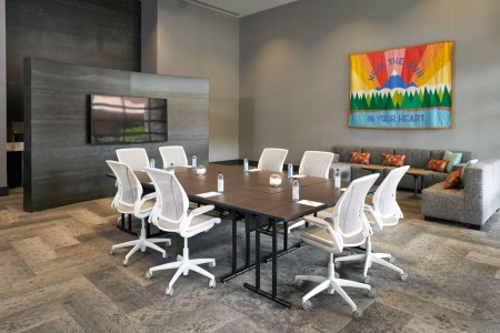 Hospitality Lounge — conference table, chairs, sofa and flat-screen TV