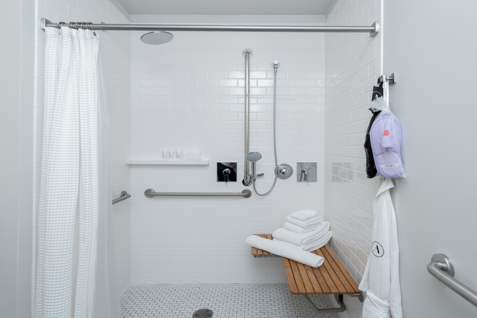 Archer's Den - spacious mobility-accessible roll-in shower with shower seat, grab bars and adjustable shower wand