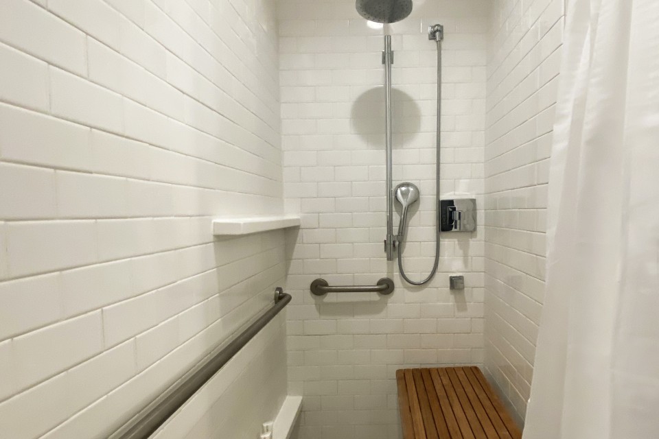 Classic King - mobility-accessible subway-tile roll-in shower with shower seat and grab bars